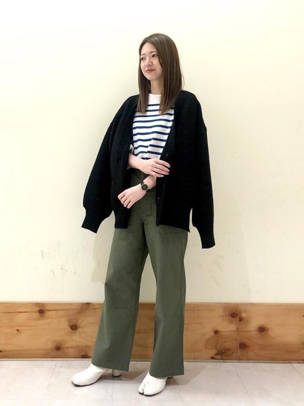 グリーン系のカーゴパンツ、ブラック系のカーディガン/ボレロ、ブルー系のTシャツ/カットソーを着用したレディースの秋コーディネートの1枚目の写真