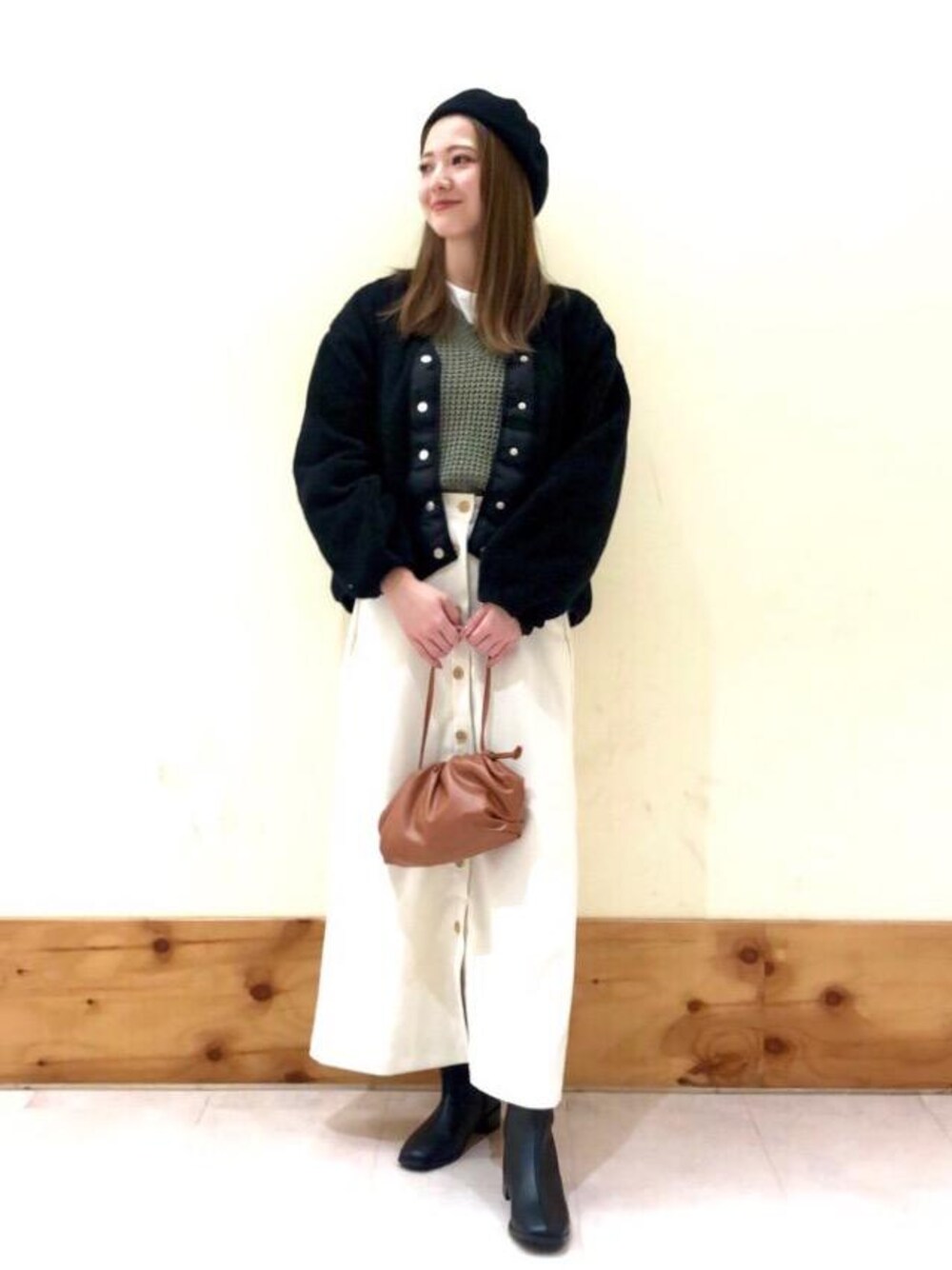 グリーン系のニット/セーター、ブラック系のブーツ、ブラウン系のショルダーバッグを着用したレディースの秋コーディネートの1枚目の写真