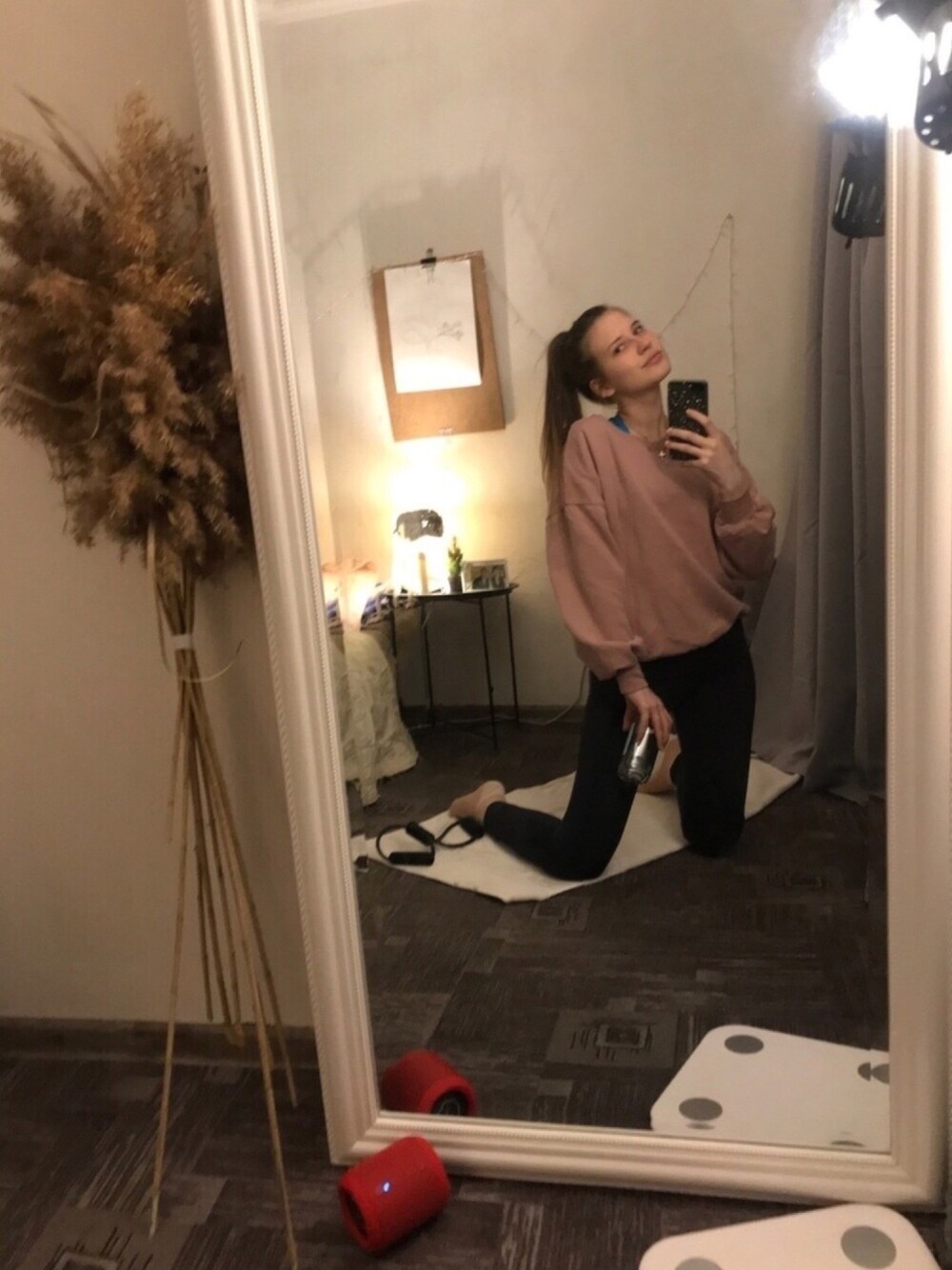 ピンク系のパーカー、ブラック系のパンツ、ホワイト系のタンクトップを着用したレディースの春コーディネートの1枚目の写真