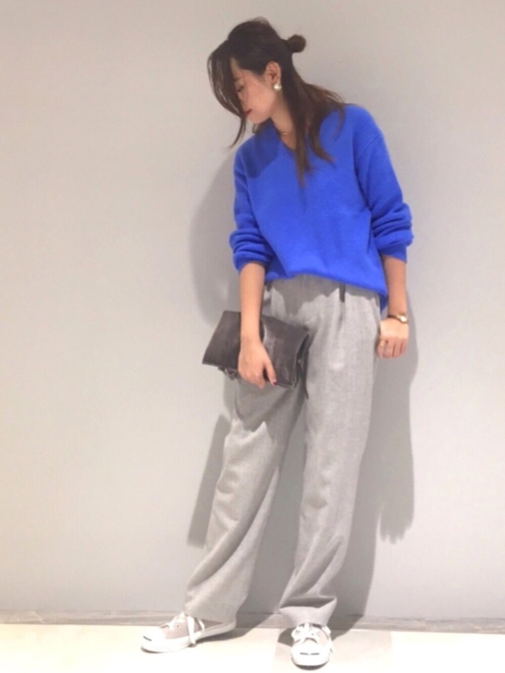 ブルー系のニット/セーター、グレー系のパンツ、グレー系のバッグを着用したレディースの秋コーディネートの1枚目の写真