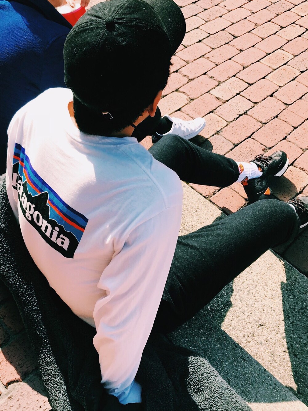 「patagonia、キャップ、黒、黒スニーカー」｜「patagoniaのアイテム（Tシャツ/カットソー、ホワイト系）」を使った、こうがさん（メンズ・181cm）の冬コーディネートの1枚目の写真