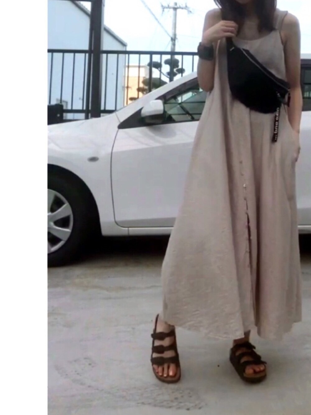 ブラック系のサンダル、ベージュ系のワンピース、ベージュ系のタンクトップを着用したレディースの夏コーディネートの1枚目の写真