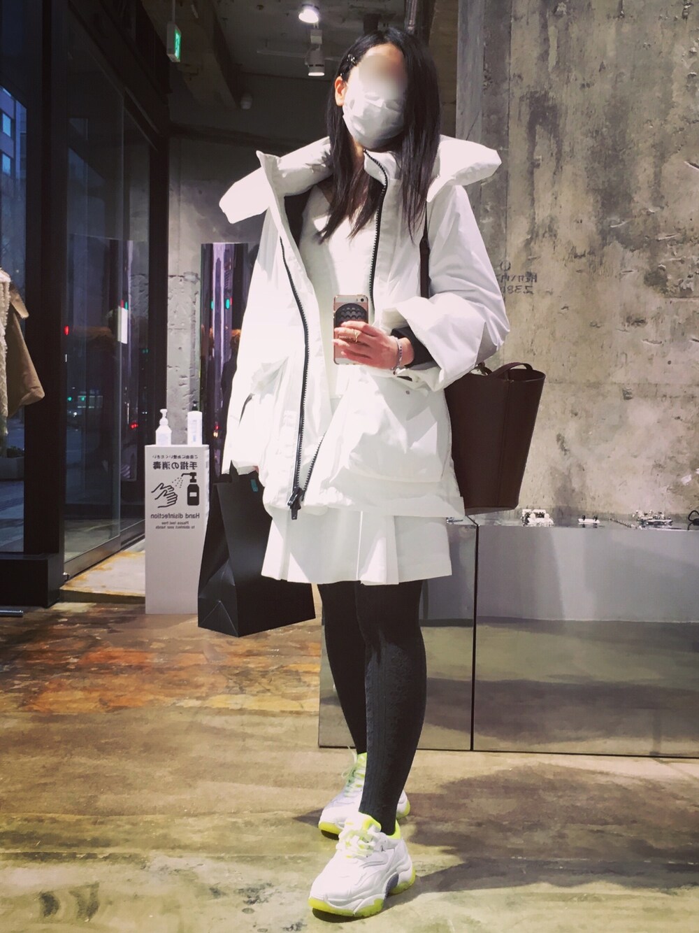 ホワイト系のダウンジャケット/コート、ホワイト系のニット/セーター、ホワイト系のスカートを着用したレディースの冬コーディネートの1枚目の写真