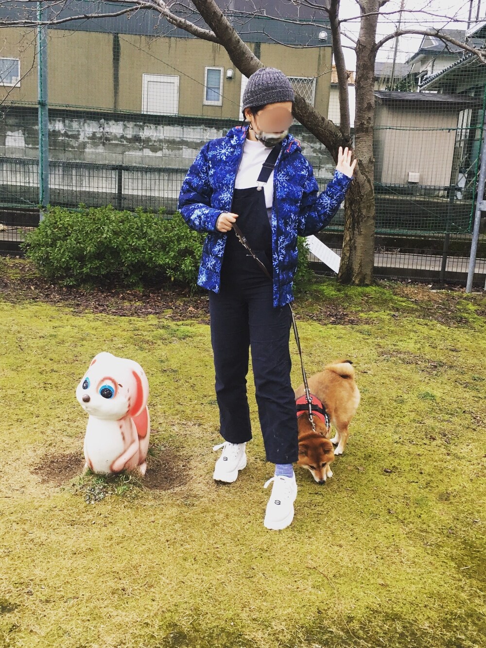 ホワイト系のスウェット、ブルー系のダウンジャケット/コート、ブルー系のサロペット/オーバーオールを着用したレディースの春コーディネートの1枚目の写真