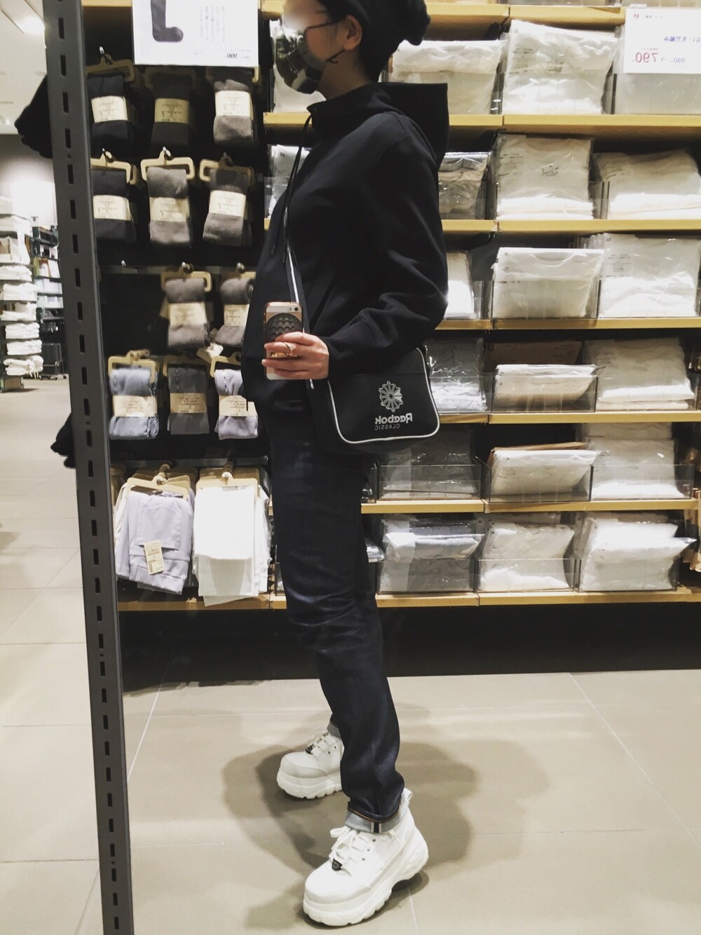 ブラック系のパーカー、ブルー系のデニムパンツ、ブラック系のショルダーバッグを着用したレディースの春コーディネートの1枚目の写真