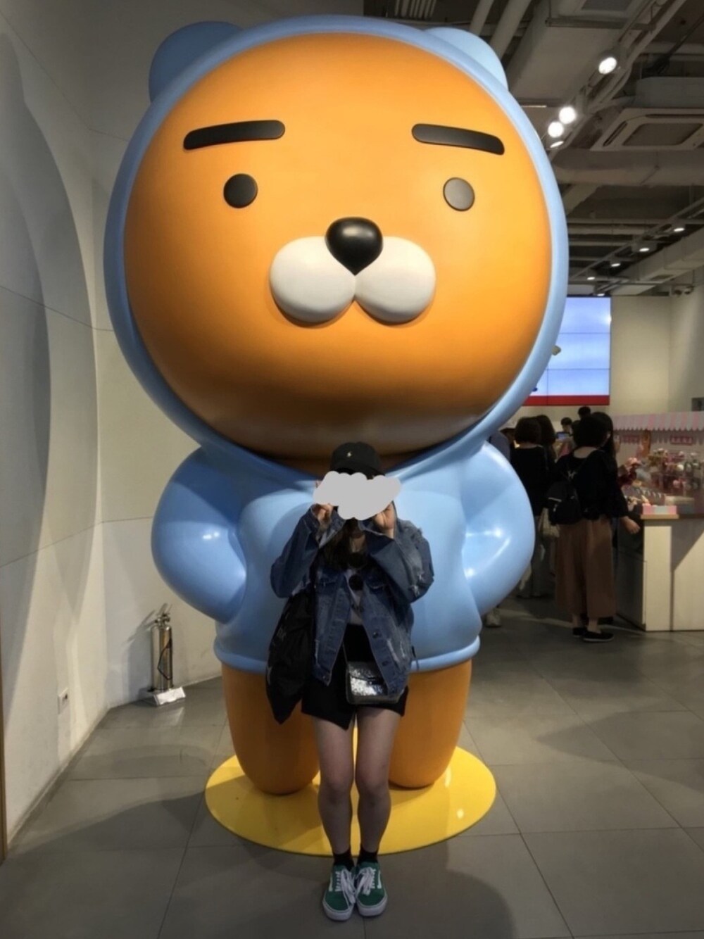 ブラック系のスカート、シルバー系のショルダーバッグ、グリーン系のスニーカーを着用したレディースの冬コーディネートの1枚目の写真