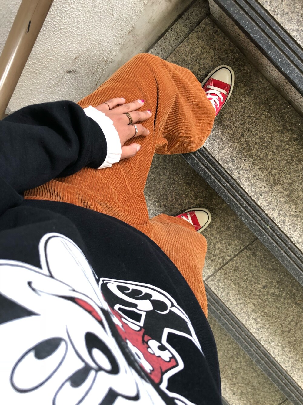 レッド系のスニーカー、イエロー系のその他パンツ、ブラック系のスウェットを着用したレディースの秋コーディネートの1枚目の写真