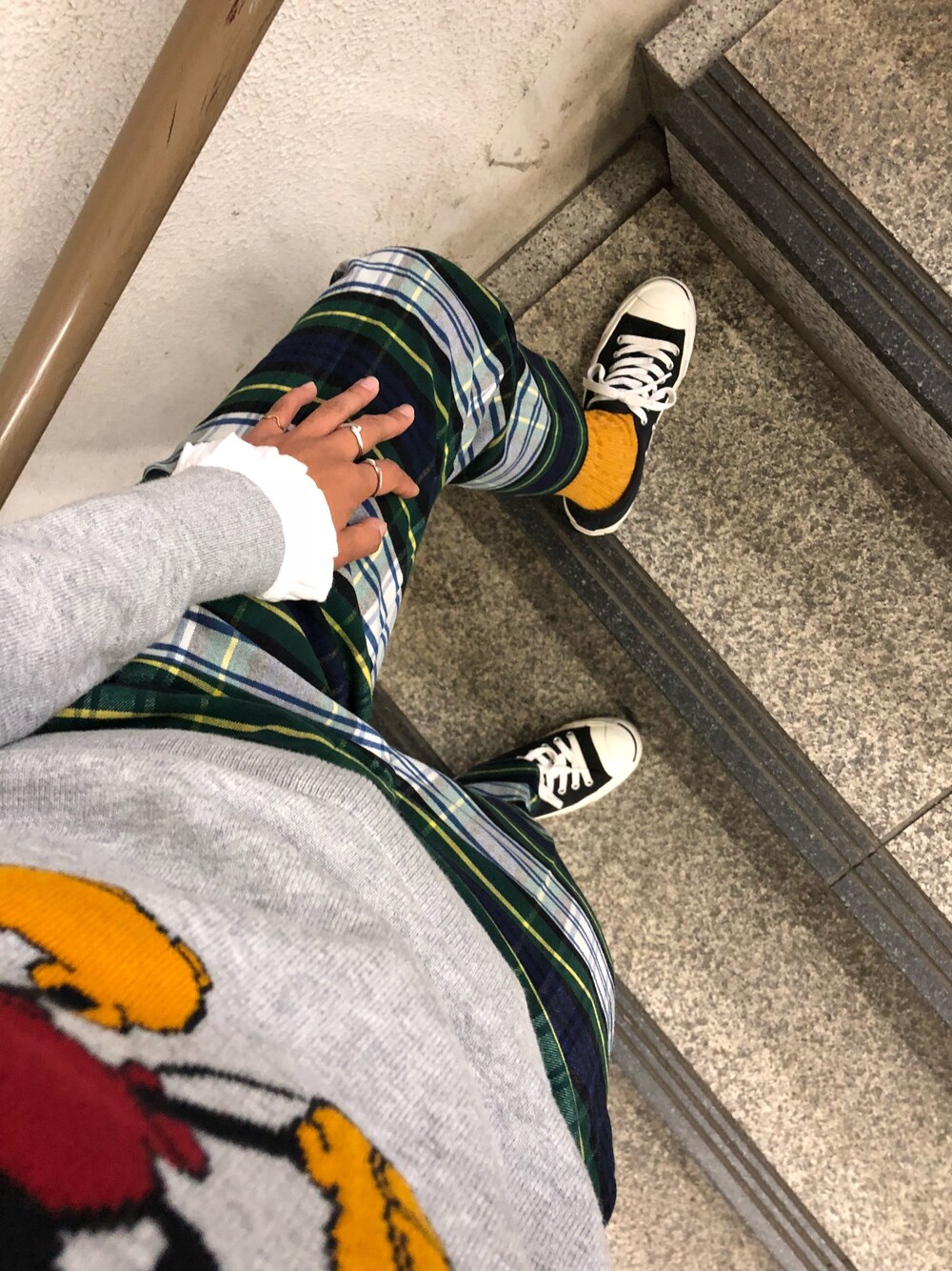 ブラック系のスニーカー、ブルー系のスラックス、グレー系のニット/セーターを着用したレディースの秋コーディネートの1枚目の写真