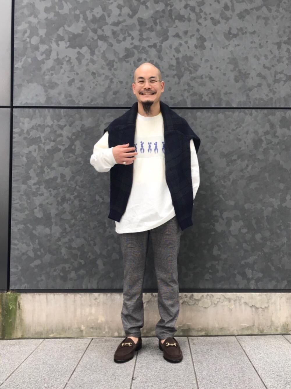 グリーン系のニット/セーター、グレー系のその他パンツ、ブラウン系のローファーを着用したメンズの秋コーディネートの1枚目の写真