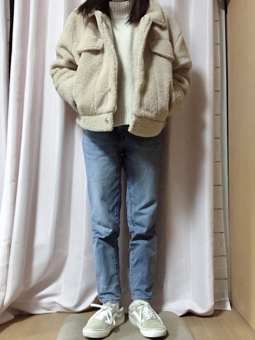 ベージュ系のジャケット/アウター、ブルー系のデニムパンツ、ベージュ系のスニーカーを着用したレディースの冬コーディネートの1枚目の写真