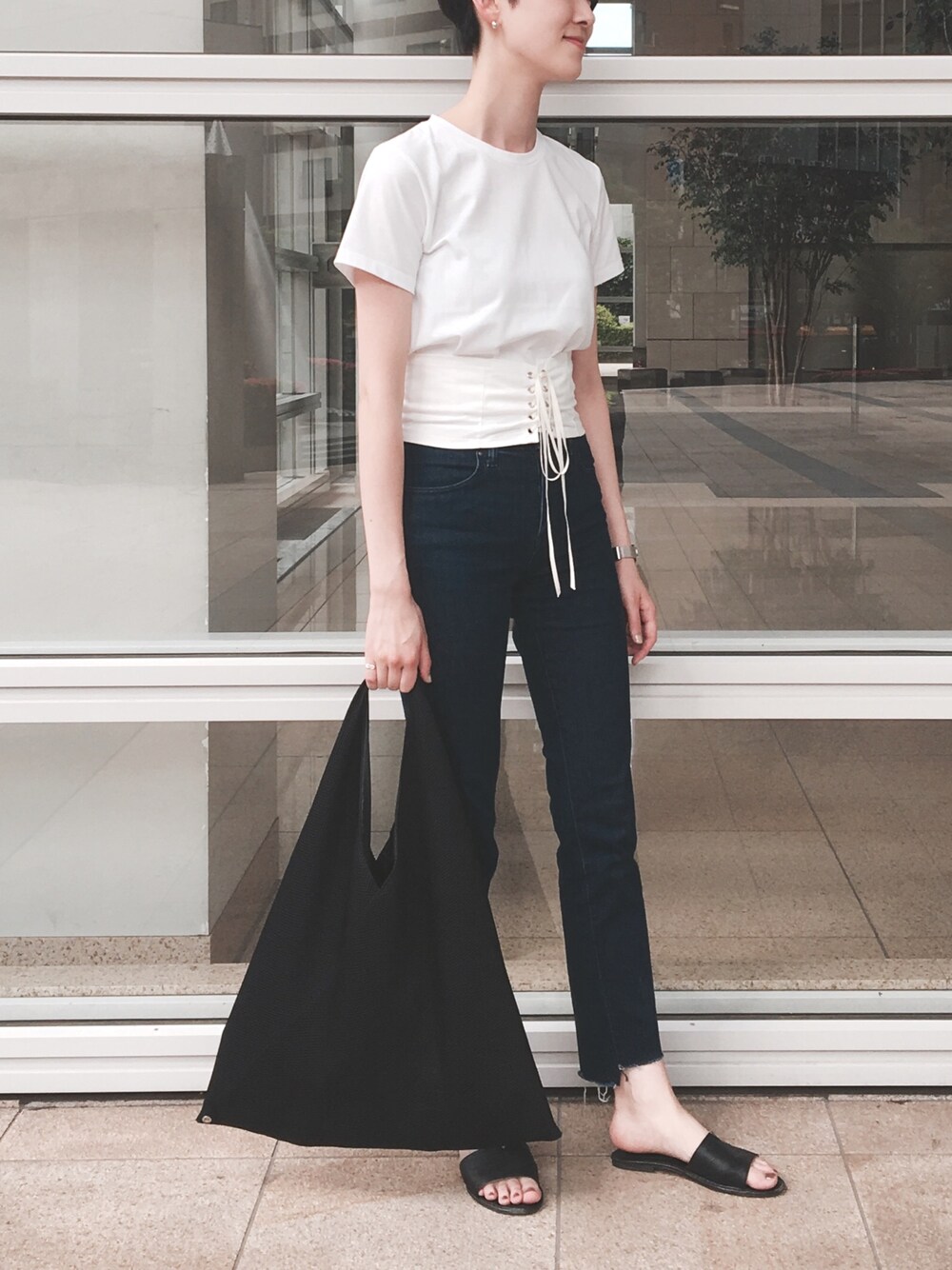 その他のサンダル、ホワイト系のTシャツ/カットソー、ブルー系のデニムパンツを着用したレディースの春コーディネートの1枚目の写真