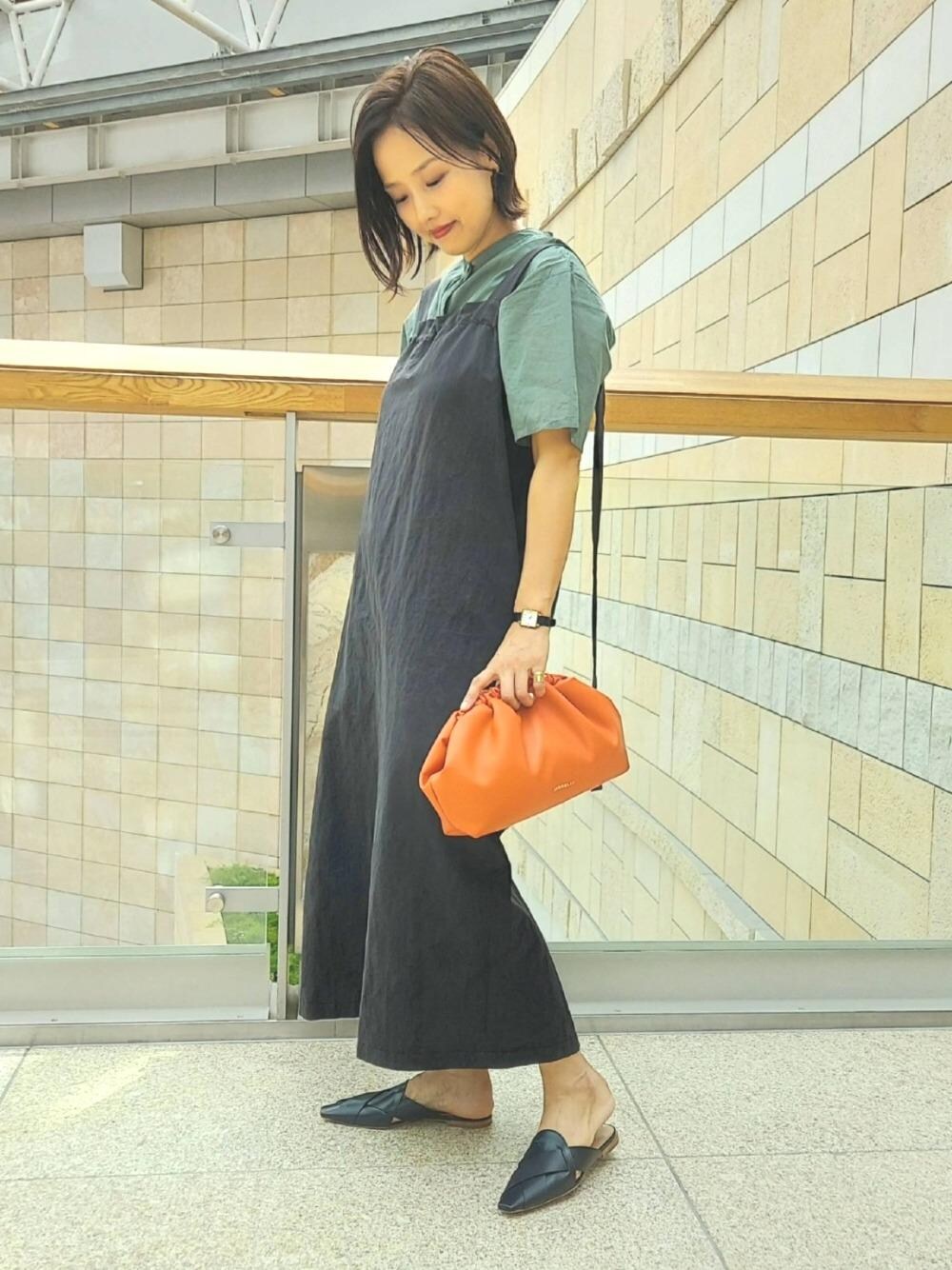 「ワンピース、ブラック、クラッチバッグ、オレンジ、スリッパ、pellico、FIORELLI、オデットエオディール、Flat shoes styling、Skirt style」｜「FIORELLIのFIORELLI EDITH（ショルダーバッグ、オレンジ系）」を使った、軍地　オデット エ オディール スタッフさん（レディース・160cm）の春コーディネートの1枚目の写真