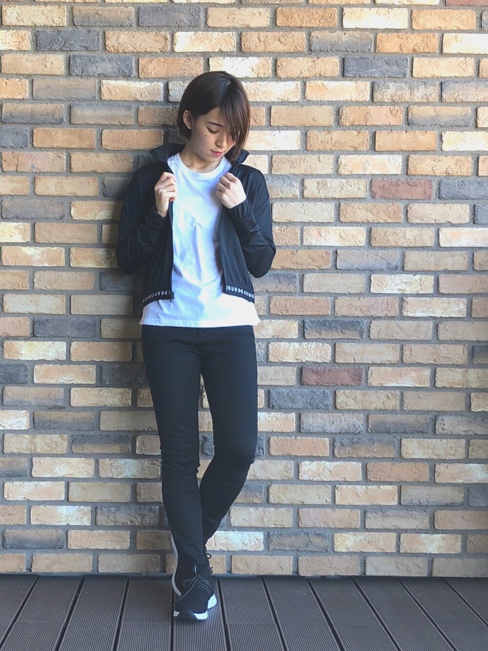 ブラック系のパーカー、ブラック系のパンツ、ブラック系のスニーカーを着用したレディースの春コーディネートの1枚目の写真