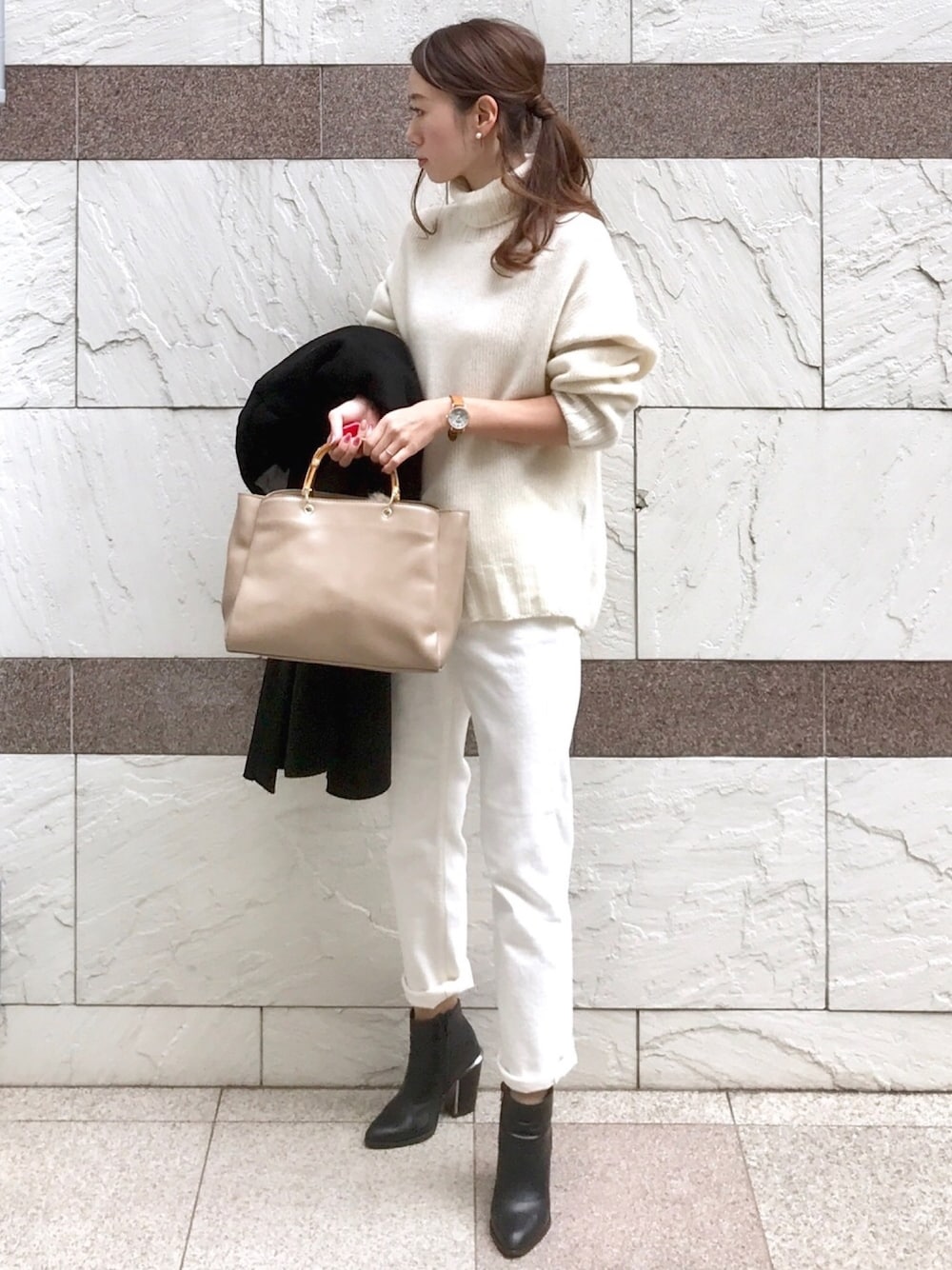 ホワイト系のデニムパンツ、ホワイト系のニット/セーター、ブラック系のブーツを着用したレディースの冬コーディネートの1枚目の写真