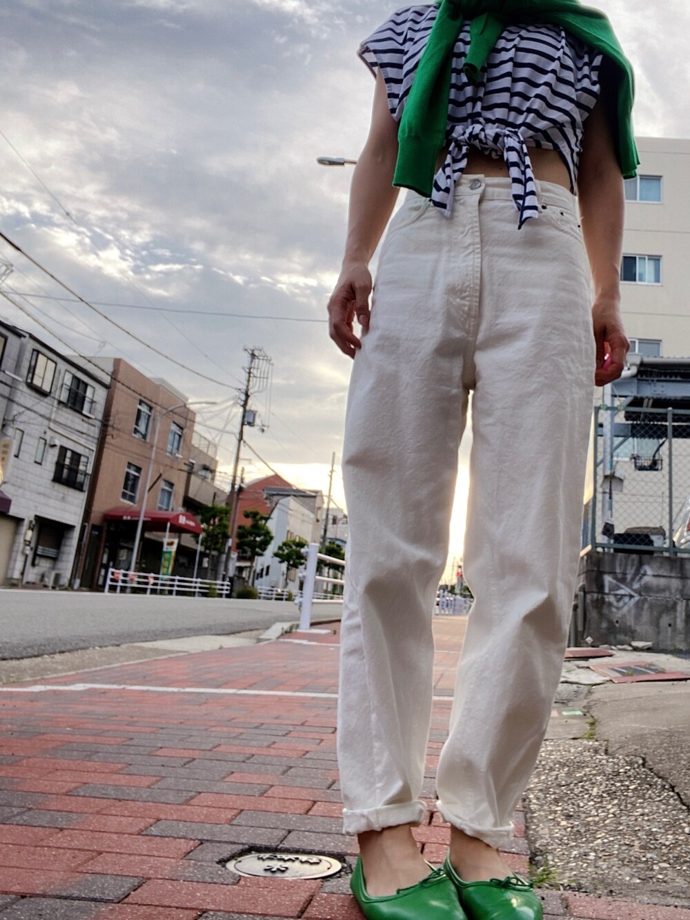 ホワイト系のデニムパンツ、グリーン系のバレエシューズ、ブルー系のTシャツ/カットソーを着用したレディースの夏コーディネートの1枚目の写真