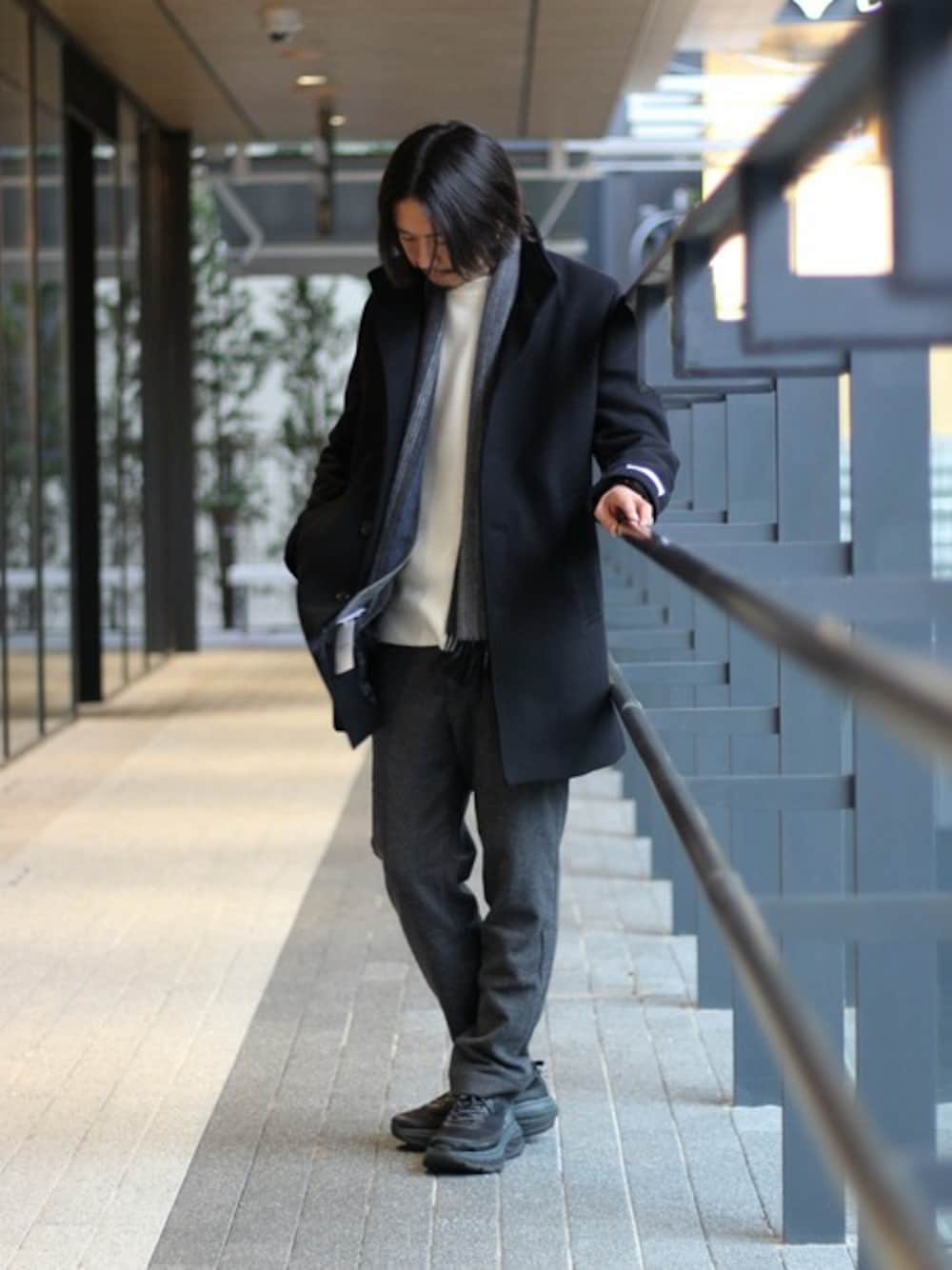 ブルー系のステンカラーコート、ホワイト系のニット/セーター、グレー系のその他パンツを着用したメンズの秋コーディネートの1枚目の写真