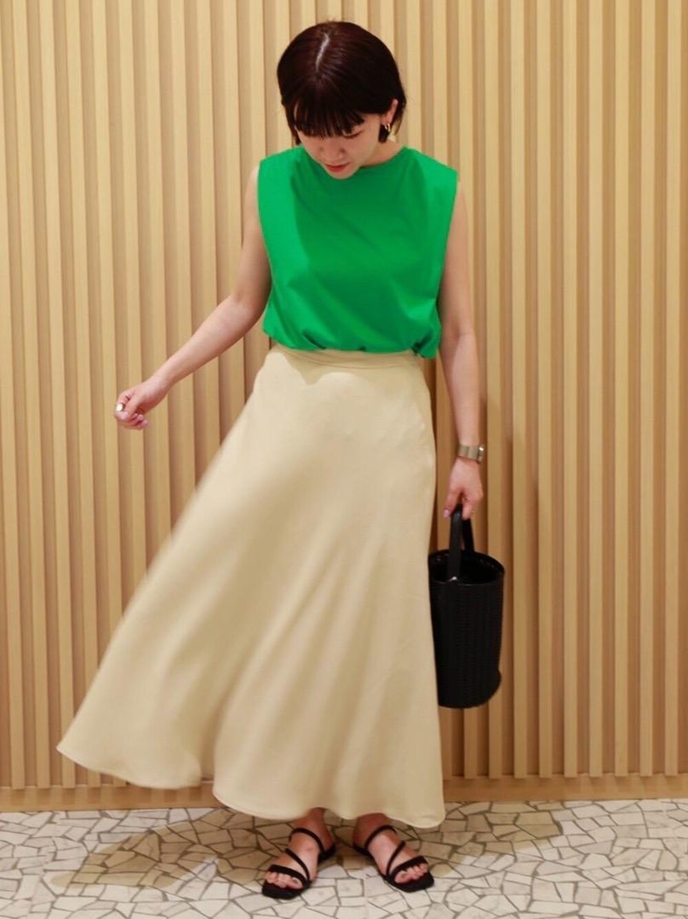 ブラック系のショルダーバッグ、ブラック系のサンダル、グリーン系のTシャツ/カットソーを着用したレディースの夏コーディネートの1枚目の写真