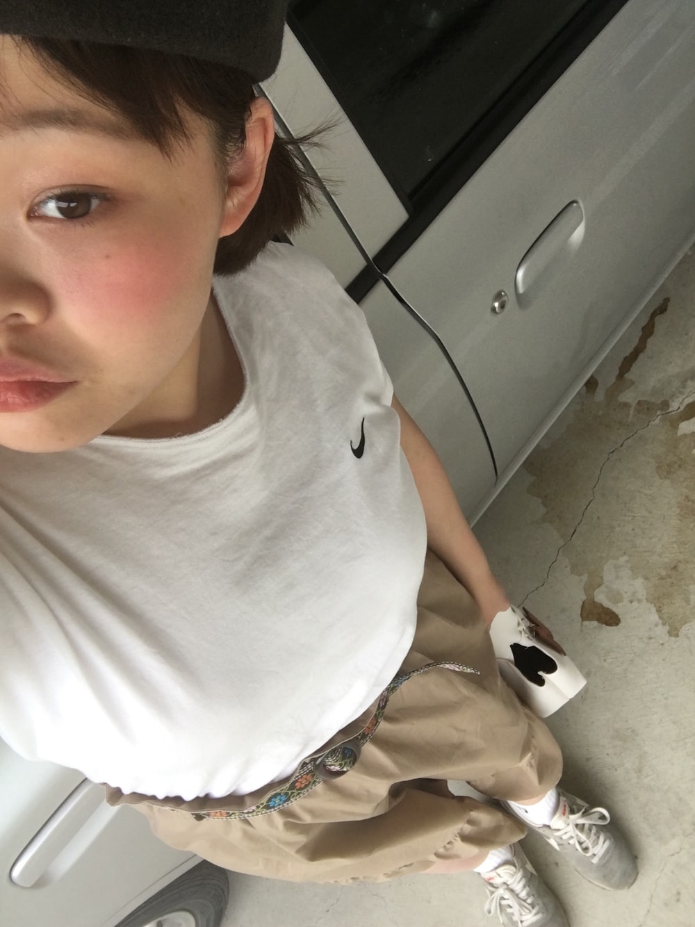 ホワイト系のTシャツ/カットソー、ベージュ系のスカート、グレー系のスニーカーを着用したレディースの秋コーディネートの1枚目の写真