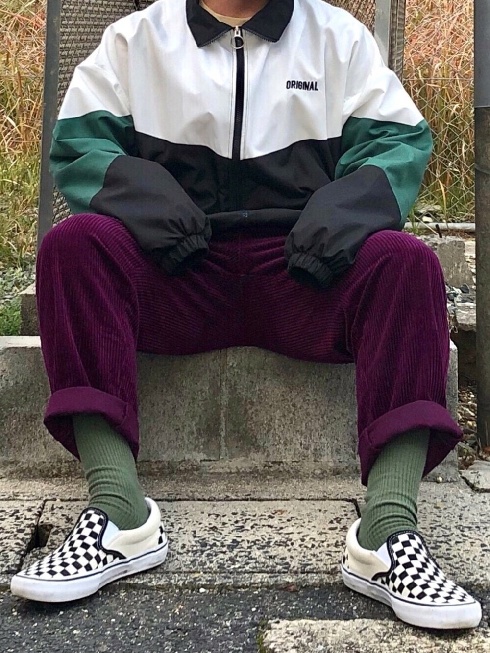 グリーン系のブルゾン、パープル系のパンツ、ブラック系のスリッポンを着用したメンズの冬コーディネートの1枚目の写真