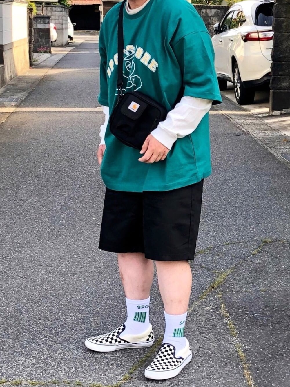 「おしゃれさんと繋がりたい、レイヤードスタイル、carhartt、プリントT、ロンT、ユニクロ、GU、ショーツ、VANS、低身長」｜「Carharttの［カーハート］ST★ CARHARTT ESS ショルダーバッグ S（ショルダーバッグ、ブラック系）」を使った、ＴａＫｕ🥑さん（メンズ・168cm）の春コーディネートの1枚目の写真