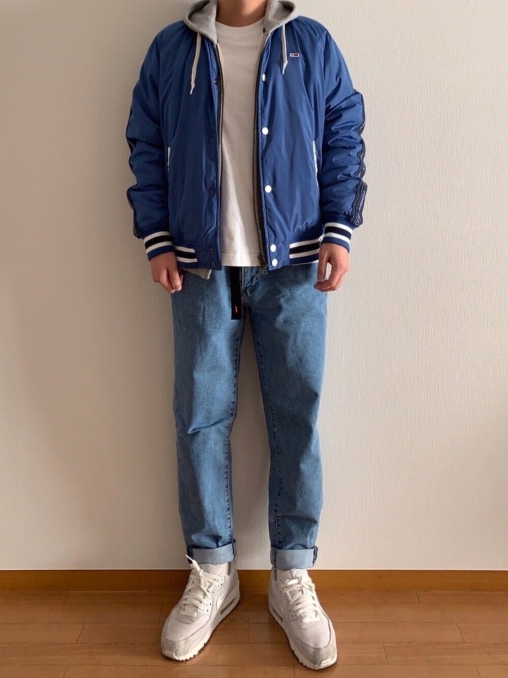 グレー系のパーカー、ホワイト系のTシャツ/カットソー、ブルー系のスタジャンを着用したメンズの冬コーディネートの1枚目の写真