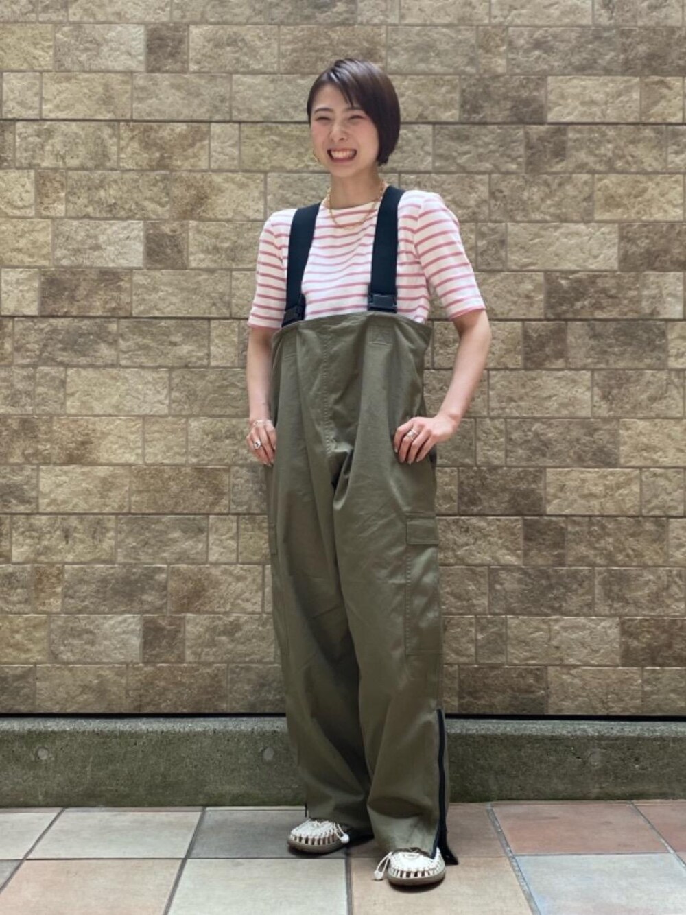 ホワイト系のサンダル、グリーン系のサロペット/オーバーオール、ピンク系のTシャツ/カットソーを着用したレディースの春コーディネートの1枚目の写真