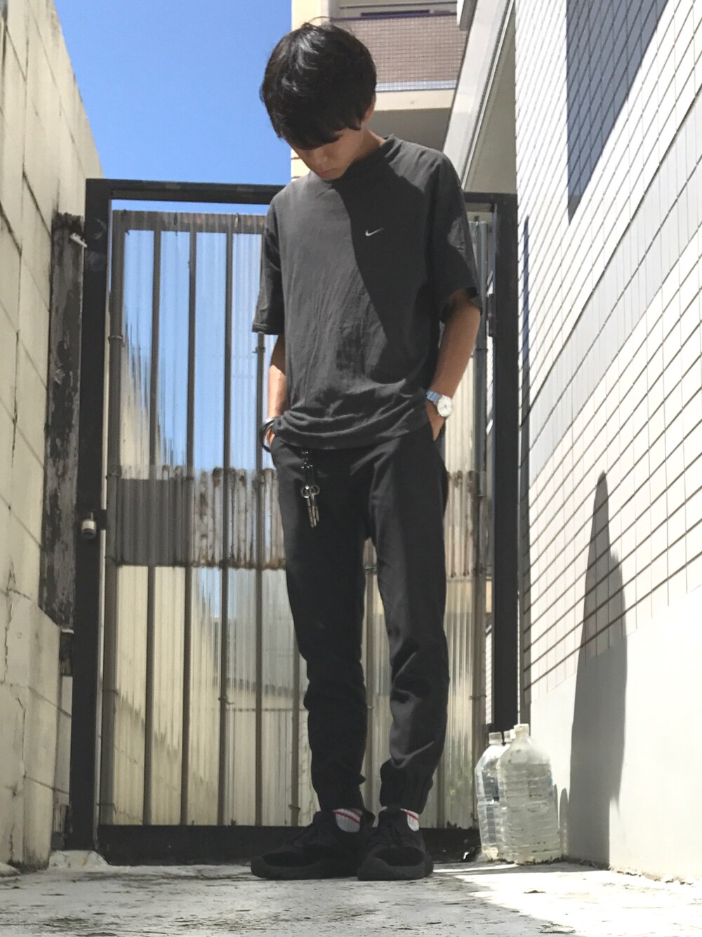 ブラック系のTシャツ/カットソー、ブラック系のスラックス、ブラック系のスニーカーを着用したメンズの秋コーディネートの1枚目の写真