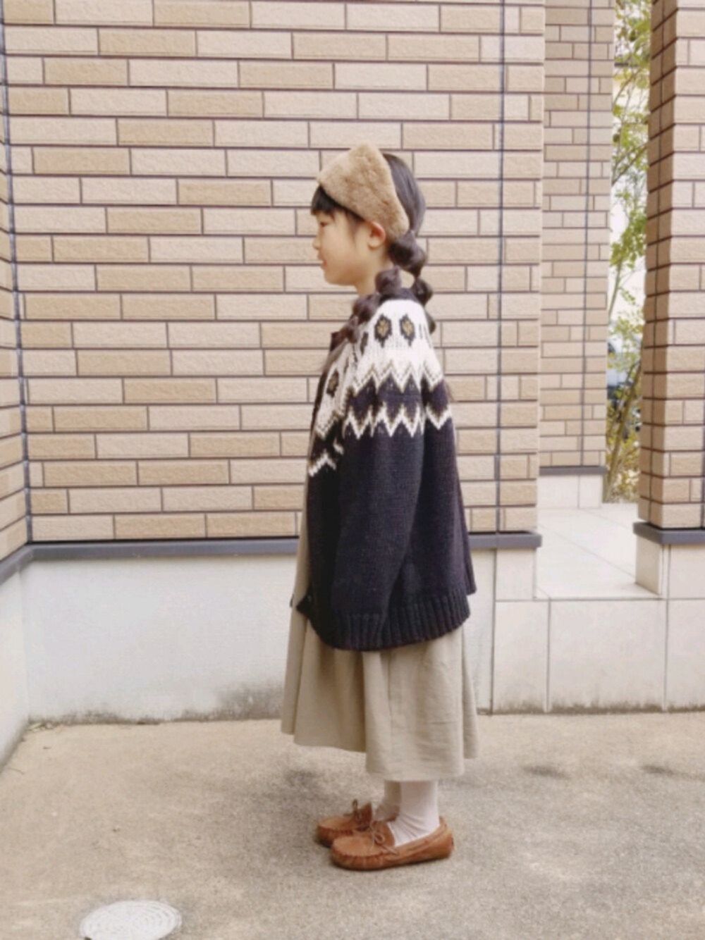「韓国子供服、おんなのこ、休日コーデ、冬コーデ、おしゃれさんと繋がりたい、カーディガン、ワンピース、モカシン、ヘアバンド、キッズコーデ」｜「koreaのアイテム（カーディガン/ボレロ、ブラック系）」を使った、あいりさん（キッズ・122cm）の春コーディネートの1枚目の写真