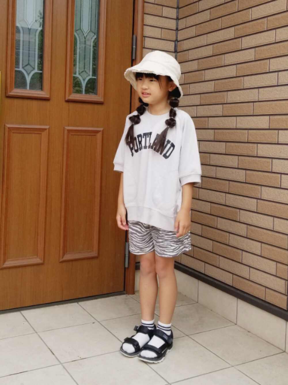 「スポーツサンダル、サンダルに靴下、ハーフパンツ、くすみカラー、リラックススタイル、休日スタイル、おしゃれさんと繋がりたい、バケットハット、おんなのこ、ゆるコーデ」｜「LOWRYS FARMのアサエコベロショートパンツ　930372（その他パンツ、グレー系）」を使った、あいりさん（キッズ・122cm）の夏コーディネートの1枚目の写真