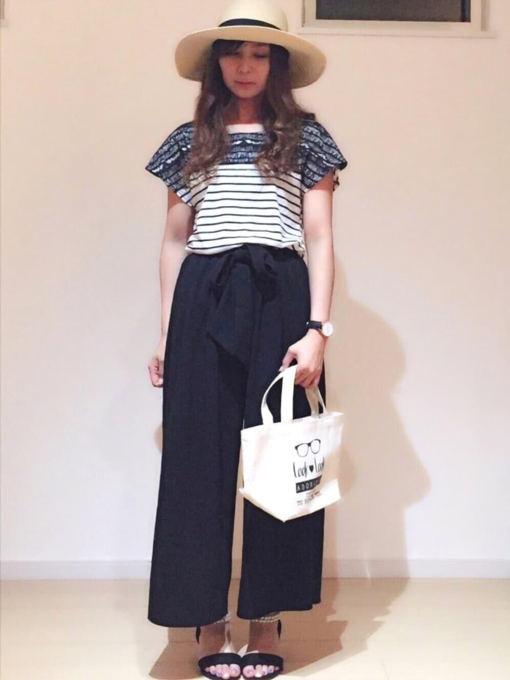 ブラック系のサンダル、ホワイト系のトートバッグ、ブラック系のその他パンツを着用したレディースの夏コーディネートの1枚目の写真