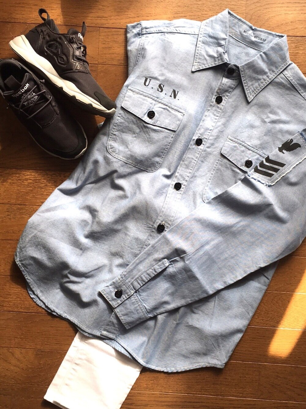 ブルー系のシャツ/ブラウス、ブラック系のスニーカー、ホワイト系のデニムパンツを着用したレディースの冬コーディネートの1枚目の写真