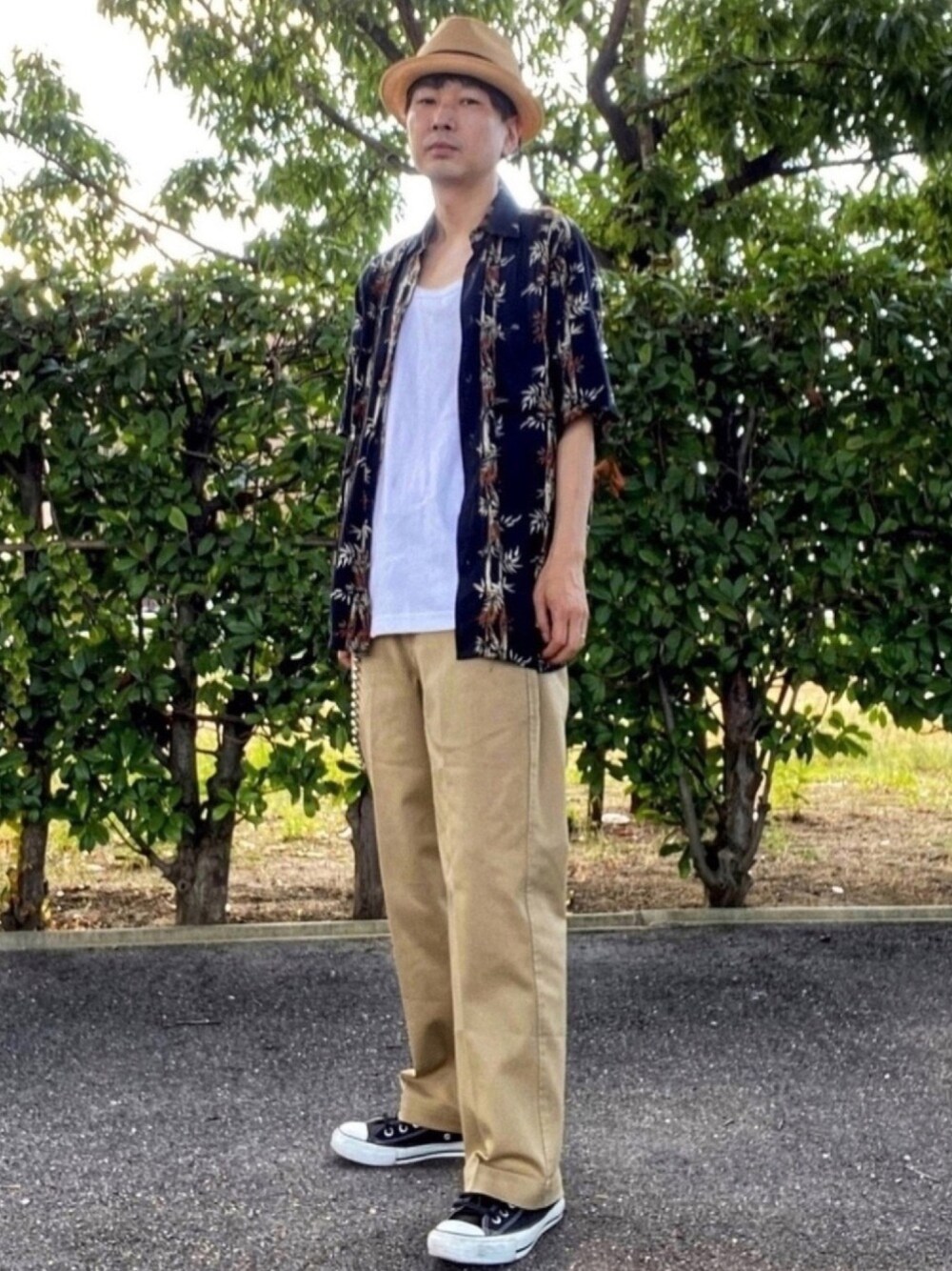 ブラック系のシャツ/ブラウス、ベージュ系のチノパンツ、ブラック系のスニーカーを着用したメンズの夏コーディネートの1枚目の写真