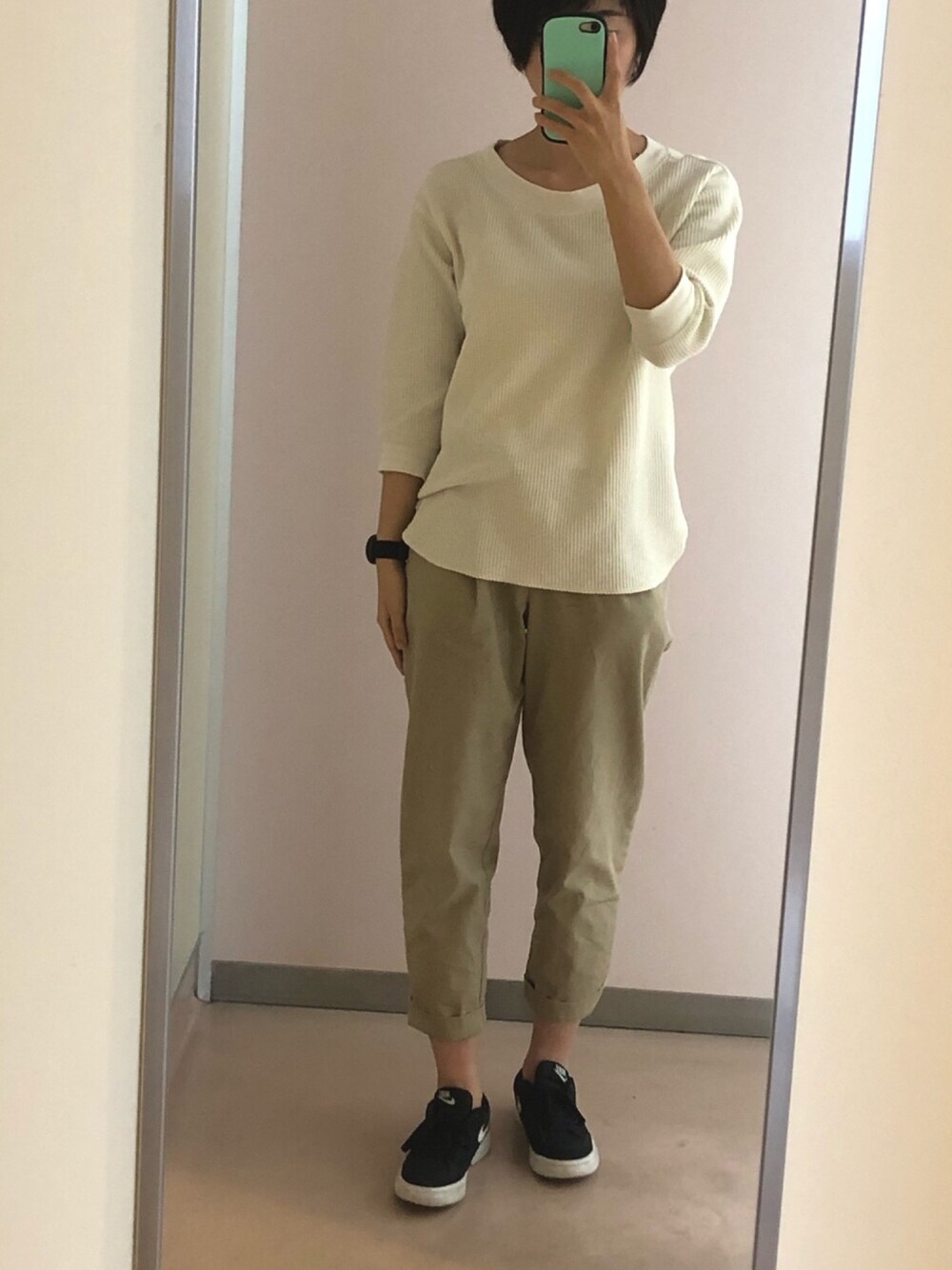 ホワイト系のTシャツ/カットソー、ベージュ系のチノパンツ、ブラック系のスニーカーを着用したレディースの夏コーディネートの1枚目の写真