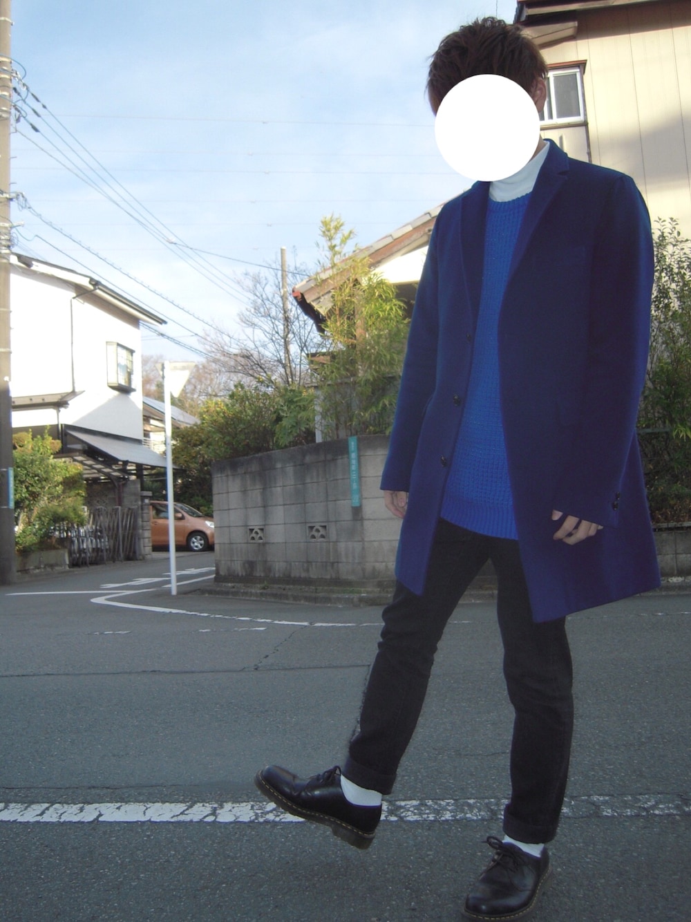 ブルー系のチェスターコート、ブルー系のニット/セーター、ホワイト系のTシャツ/カットソーを着用したメンズの冬コーディネートの1枚目の写真