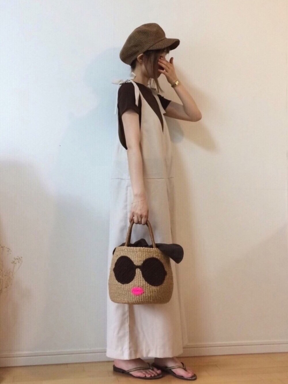 ベージュ系のサロペット/オーバーオール、ブラウン系のかごバッグ、ブラウン系のTシャツ/カットソーを着用したレディースの夏コーディネートの1枚目の写真