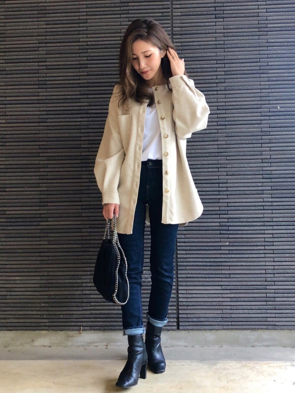 ベージュ系のシャツ/ブラウス、ホワイト系のTシャツ/カットソー、ブルー系のデニムパンツを着用したレディースの秋コーディネートの1枚目の写真
