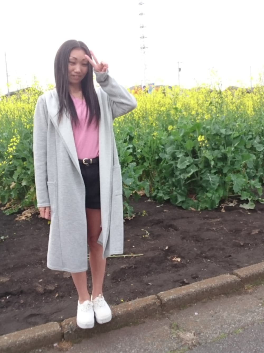 グレー系のその他アウター、ホワイト系のスニーカー、ピンク系のニット/セーターを着用したレディースの春コーディネートの1枚目の写真