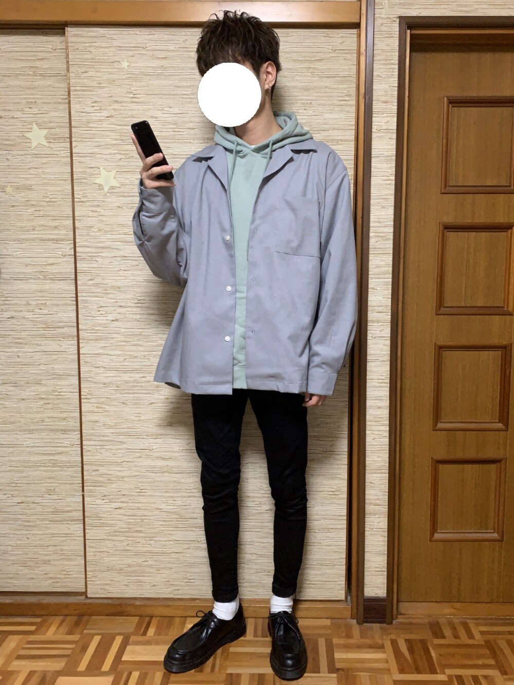 グリーン系のパーカー、グレー系のトップス、ブラック系のデニムパンツを着用したメンズの冬コーディネートの1枚目の写真