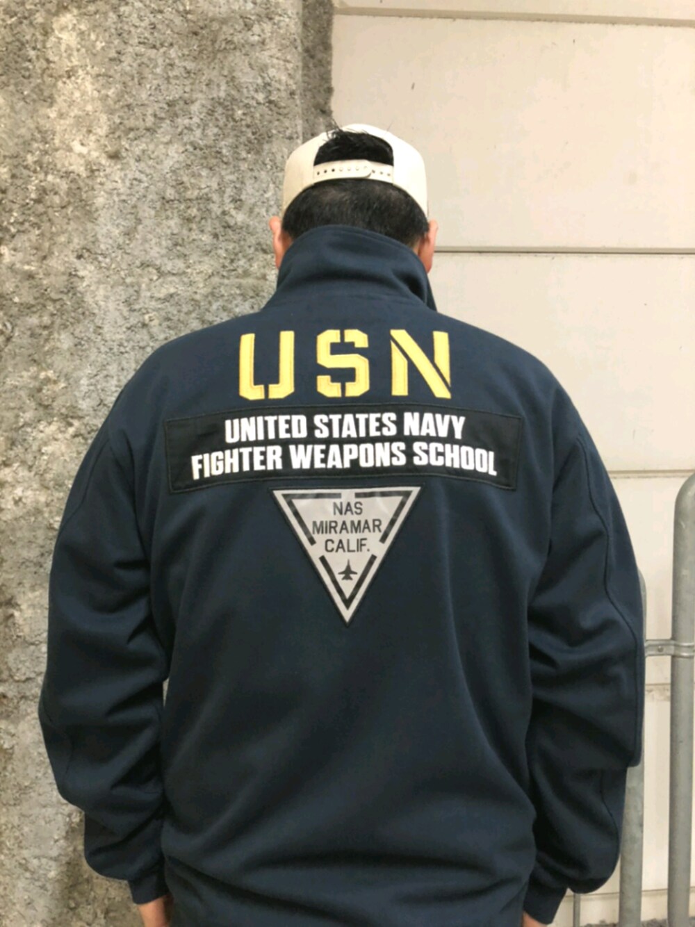 ブルー系のパーカー、ベージュ系のキャップを着用したメンズの夏コーディネートの1枚目の写真