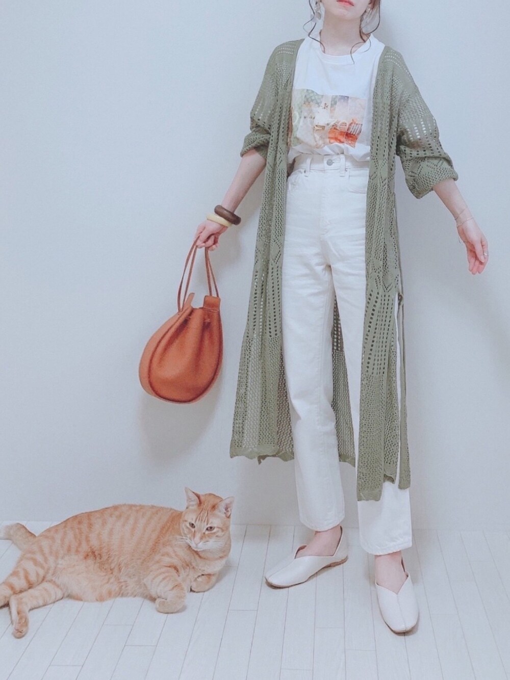 グリーン系のカーディガン/ボレロ、ホワイト系のTシャツ/カットソー、ホワイト系のデニムパンツを着用したレディースの春コーディネートの1枚目の写真