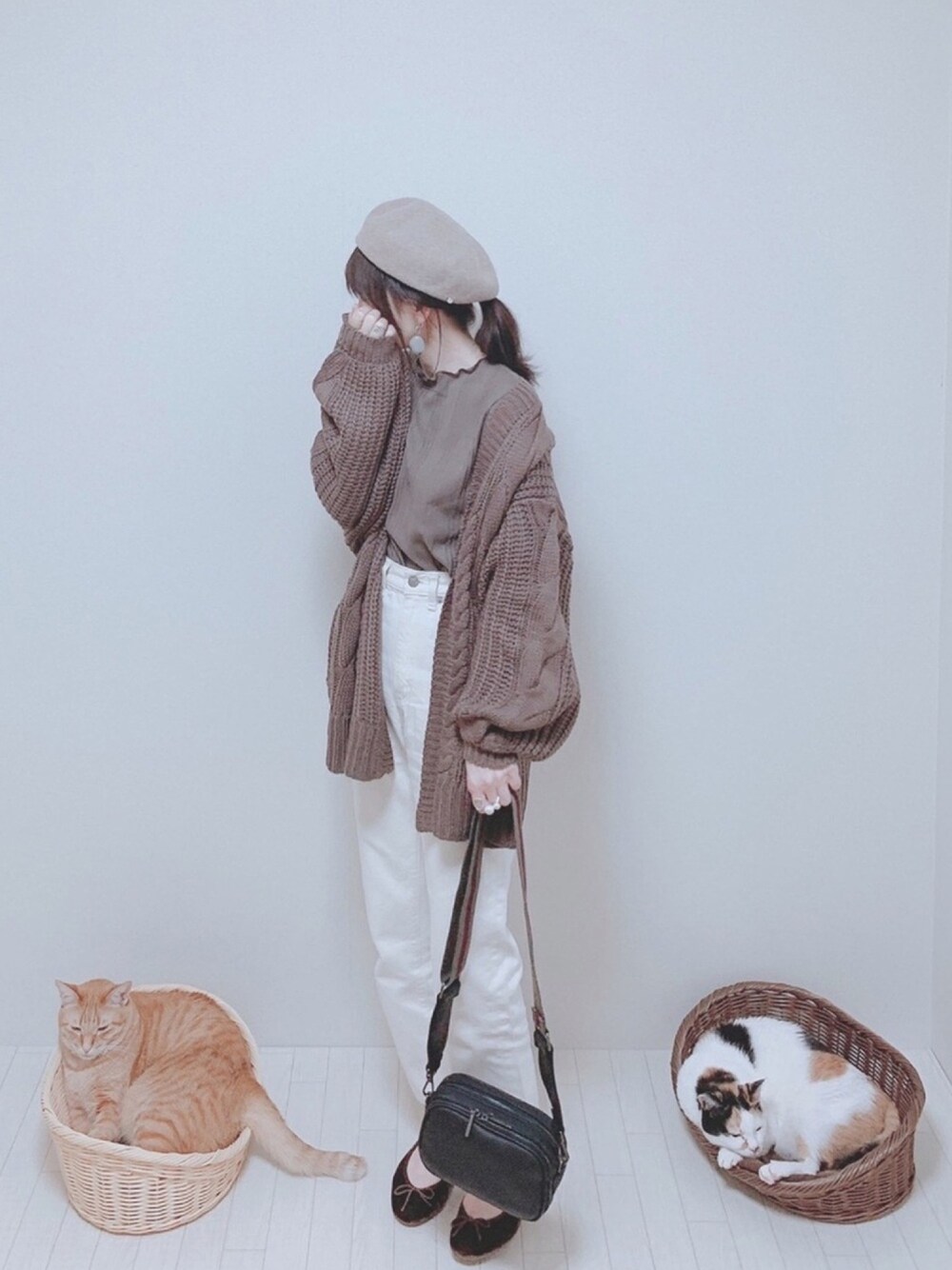 ブラウン系のカーディガン/ボレロ、ブラウン系のトップス、ホワイト系のパンツを着用したレディースの秋コーディネートの1枚目の写真