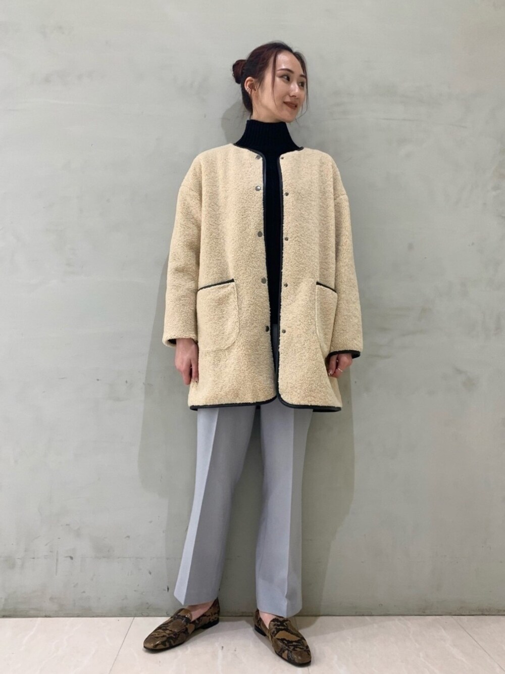 ベージュ系のノーカラージャケット、ブルー系のその他パンツ、ブラック系のニット/セーターを着用したレディースの冬コーディネートの1枚目の写真