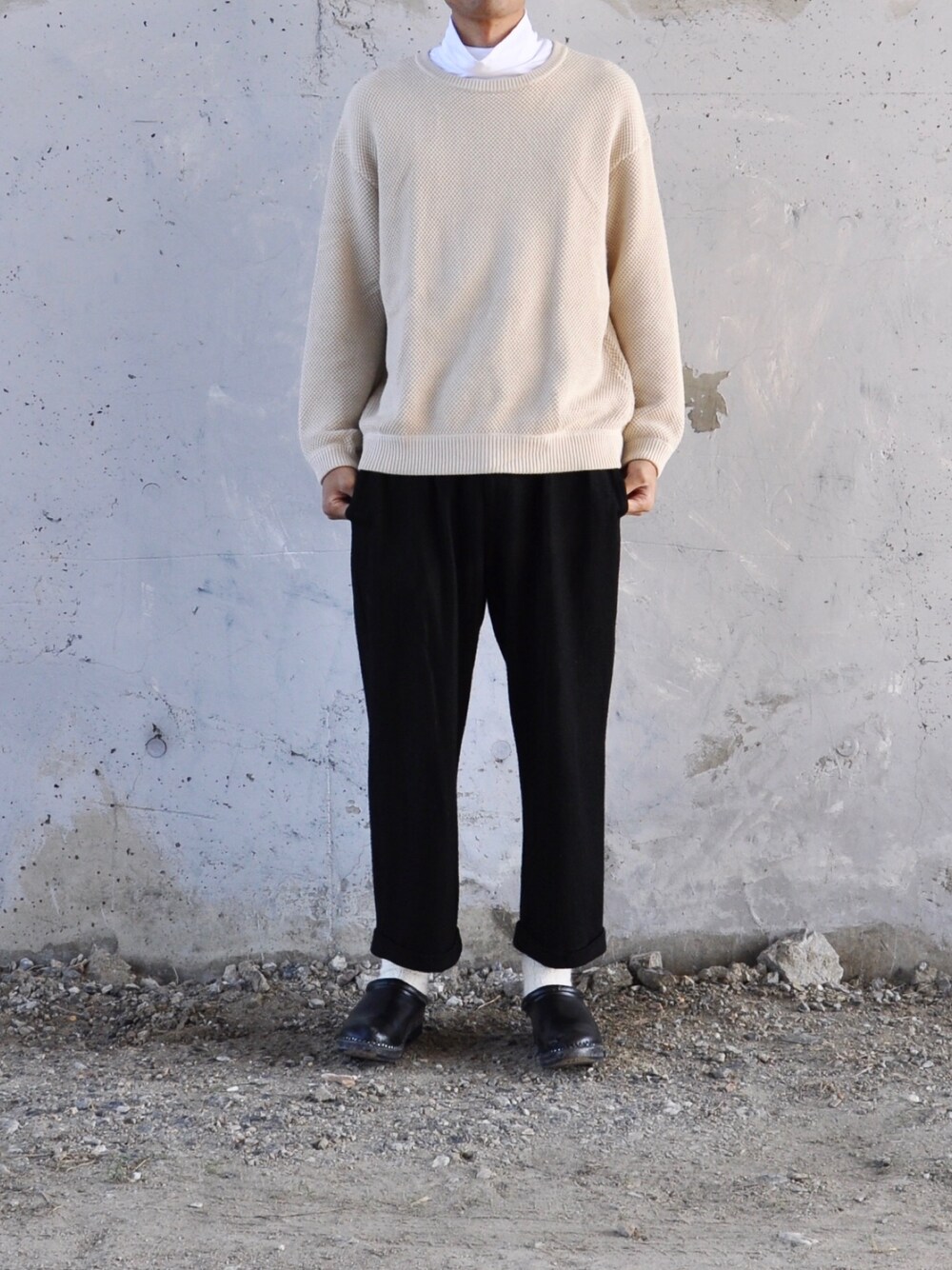 ベージュ系のニット/セーター、ホワイト系のTシャツ/カットソー、ブラック系のパンツを着用したメンズの秋コーディネートの1枚目の写真