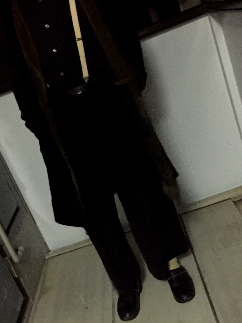 ブラック系のスラックス、ブラック系のサンダル、ブラック系のベストを着用したメンズの冬コーディネートの1枚目の写真