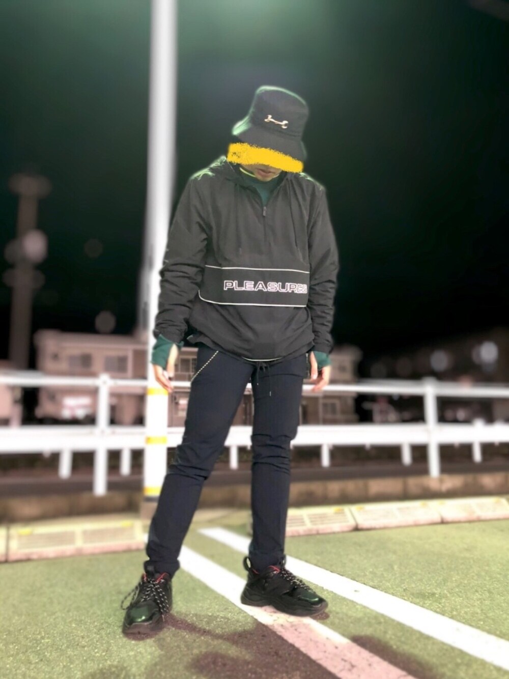 グリーン系のTシャツ/カットソー、ブラック系のナイロンジャケット、ブルー系のスラックスを着用したメンズの冬コーディネートの1枚目の写真