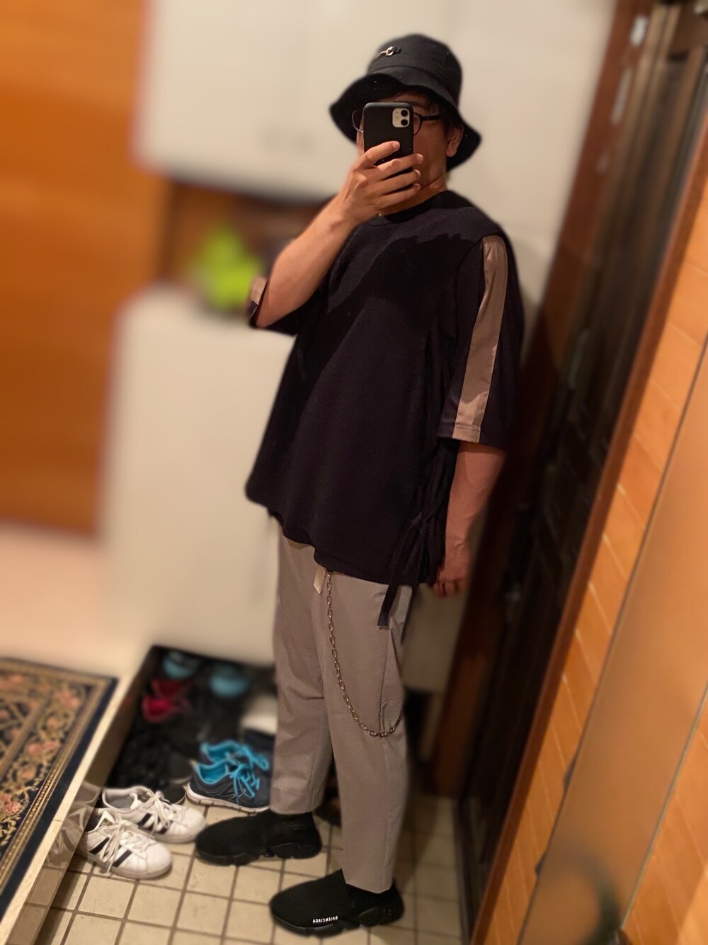 ブラック系のTシャツ/カットソー、ブラック系のベスト、グレー系のスラックスを着用したメンズの夏コーディネートの1枚目の写真