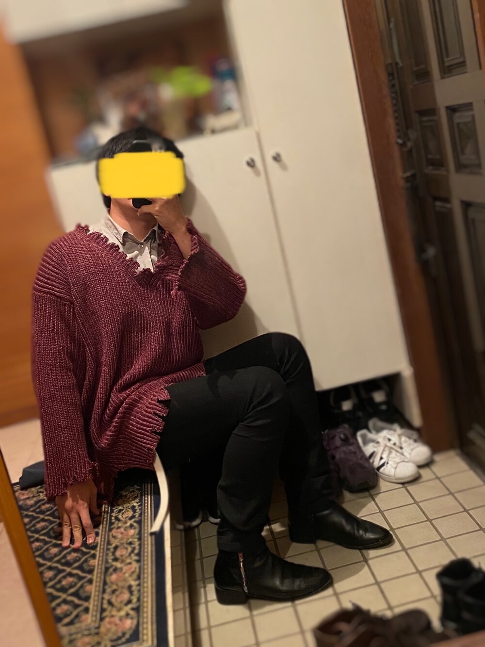 グレー系のシャツ/ブラウス、レッド系のニット/セーター、ブラック系のデニムパンツを着用したメンズの冬コーディネートの1枚目の写真