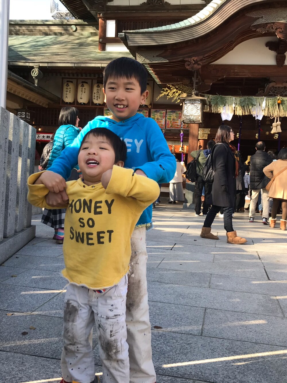 イエロー系のパーカー、ホワイト系のパンツ、ブルー系のパーカーを着用したキッズの秋コーディネートの1枚目の写真