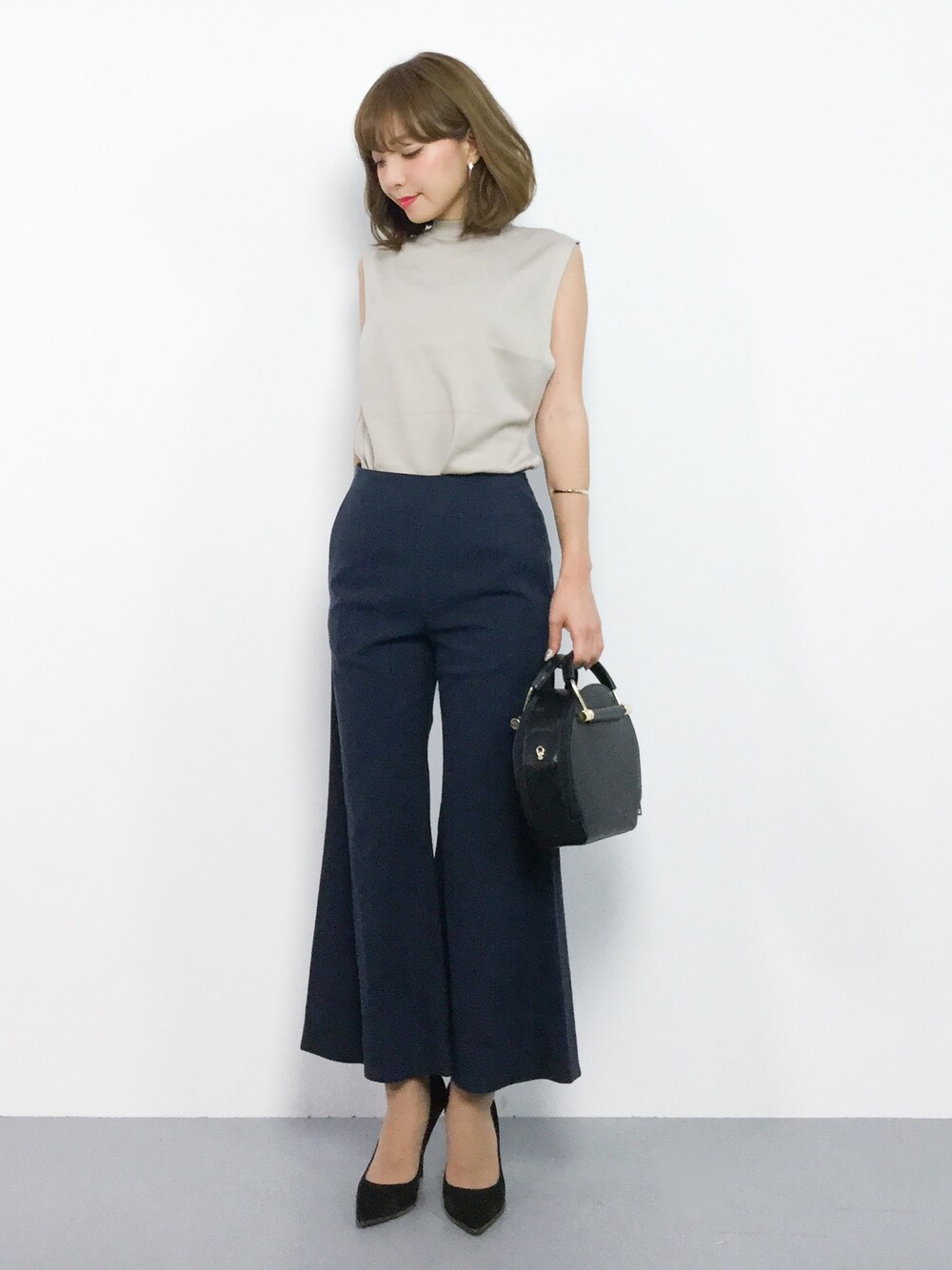 ブルー系のその他パンツ、ベージュ系のニット/セーター、ブラック系のショルダーバッグを着用したレディースの夏コーディネートの1枚目の写真