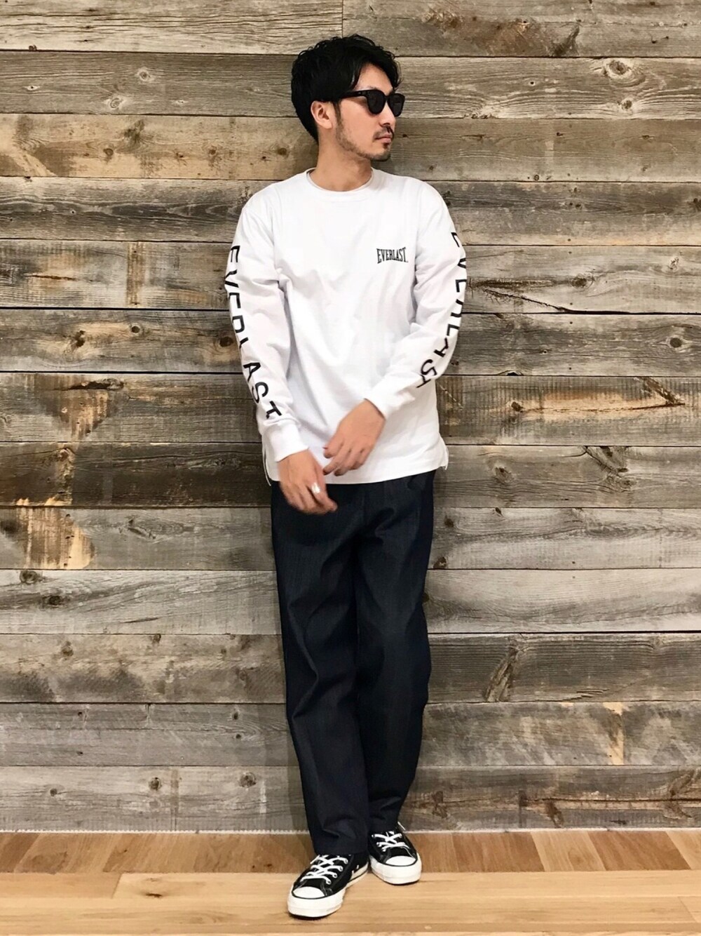 ホワイト系のTシャツ/カットソー、ブルー系のデニムパンツ、ブラック系のスニーカーを着用したメンズの秋コーディネートの1枚目の写真